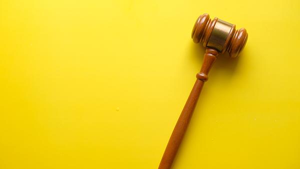 Kuvituskuva, jossa puheenjohtajan nuija keltaisella taustalla.