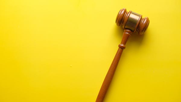 Kuvituskuva, jossa puheenjohtajan nuija keltaisella taustalla.