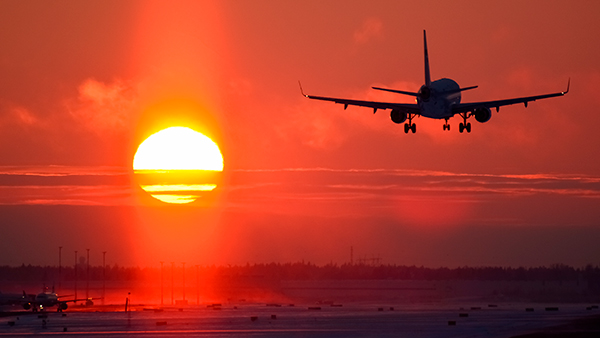 Lentokone laskeutuu auringonlaskuun
