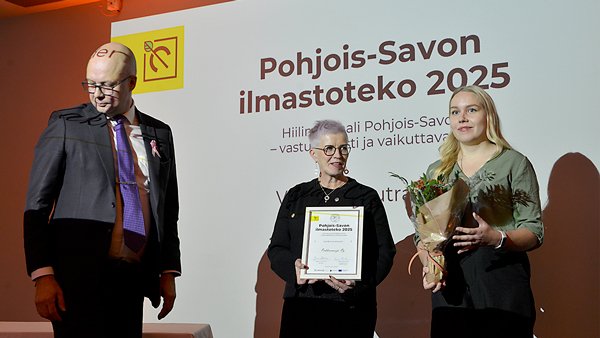 Palkinnon saajat ja luovuttaja kuvassa