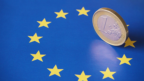 Kuvituskuva, jossa euron kolikko EU-lipun päällä